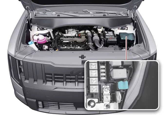 Using the specialized fuse puller tool to extract a blade fuse from the interior panel of a Kia Telluride