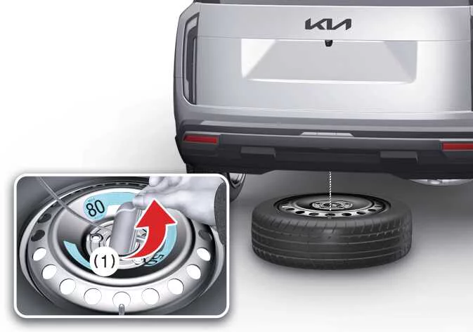 Turning lug wrench counterclockwise to lower spare tire from beneath Kia Telluride chassis
