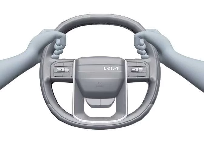 Driver holding the steering wheel correctly on an unpaved road in a Kia Telluride